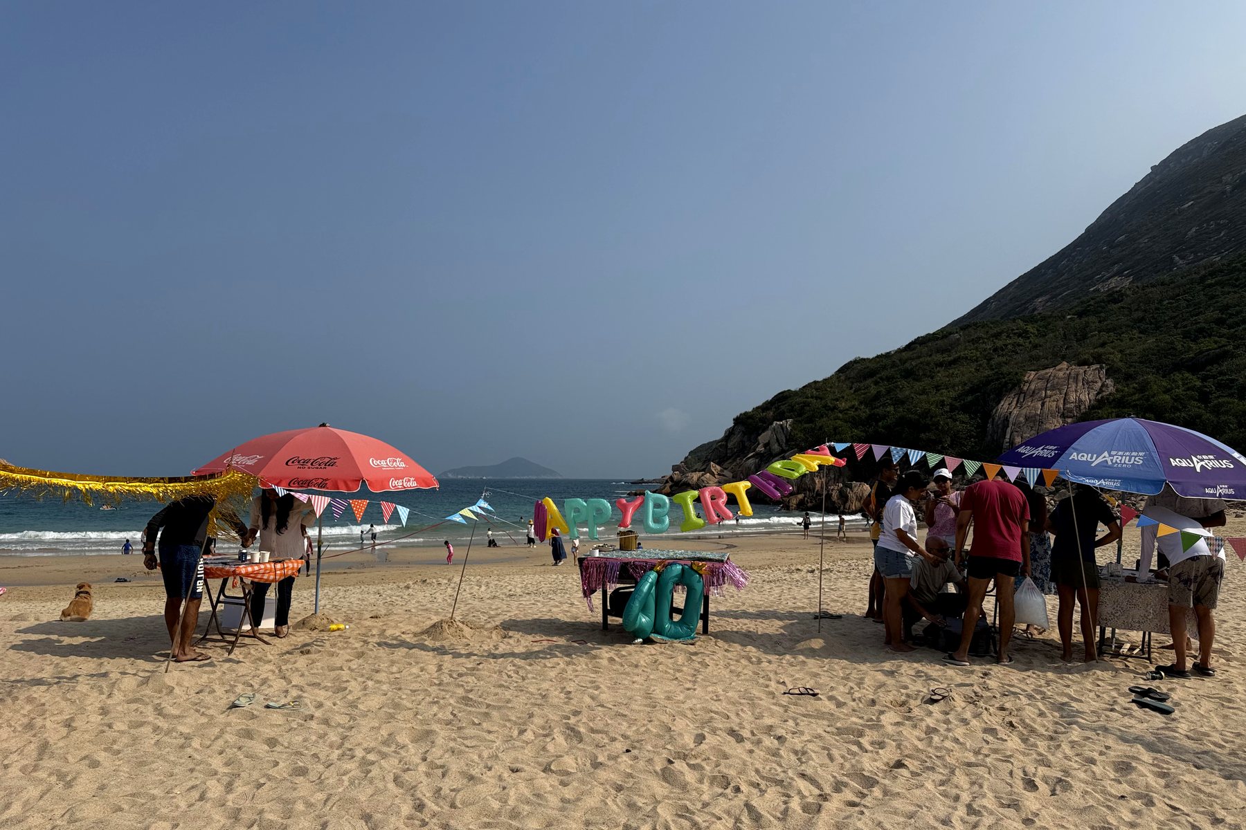 Parasols, bunting and giant birthday letters set up on a beach