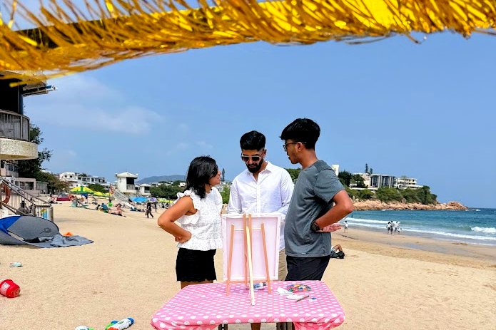 Guests painting at an easel on the beach