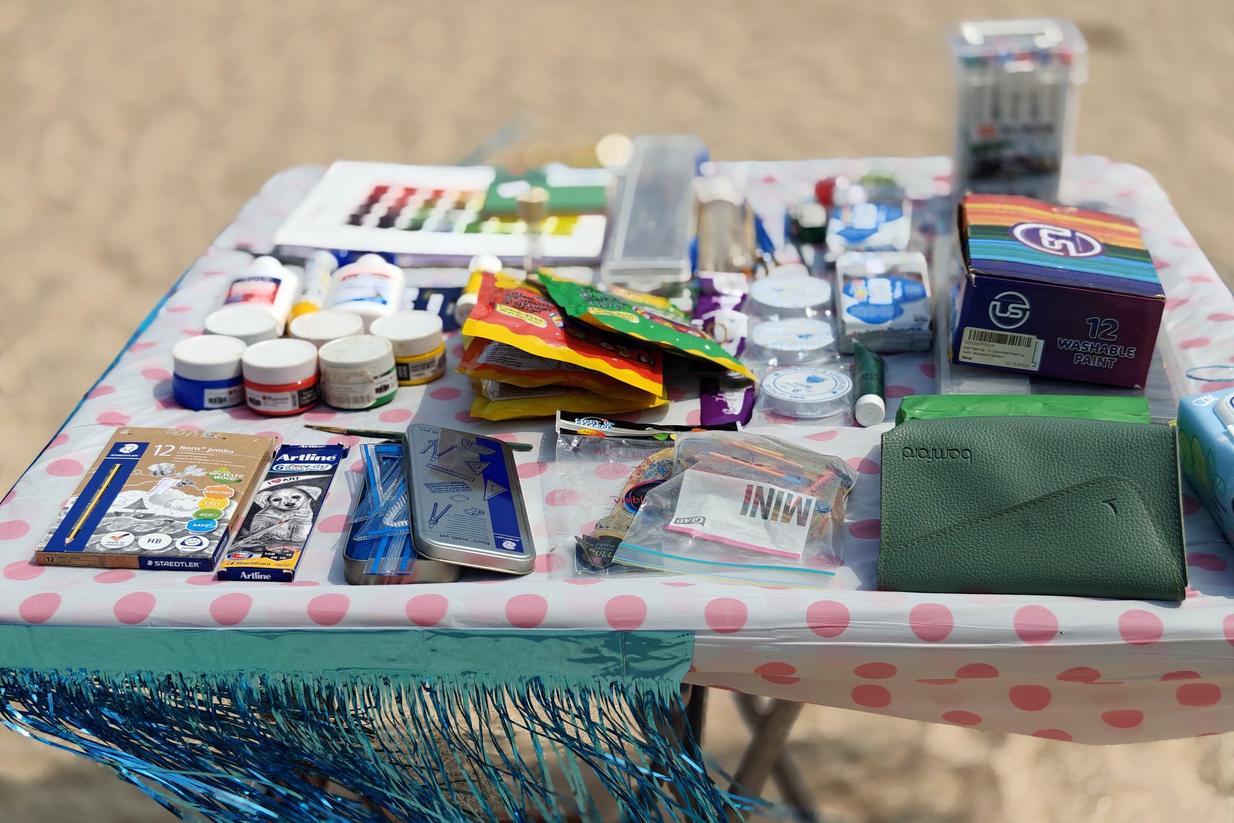 A table of paints, brushes and craft materials