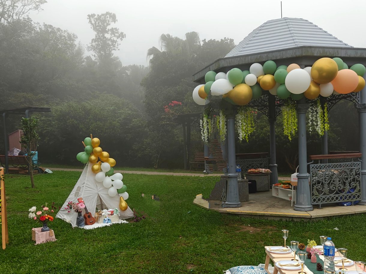 A misty lawn with a dressed bandstand, a teepee and a laid table