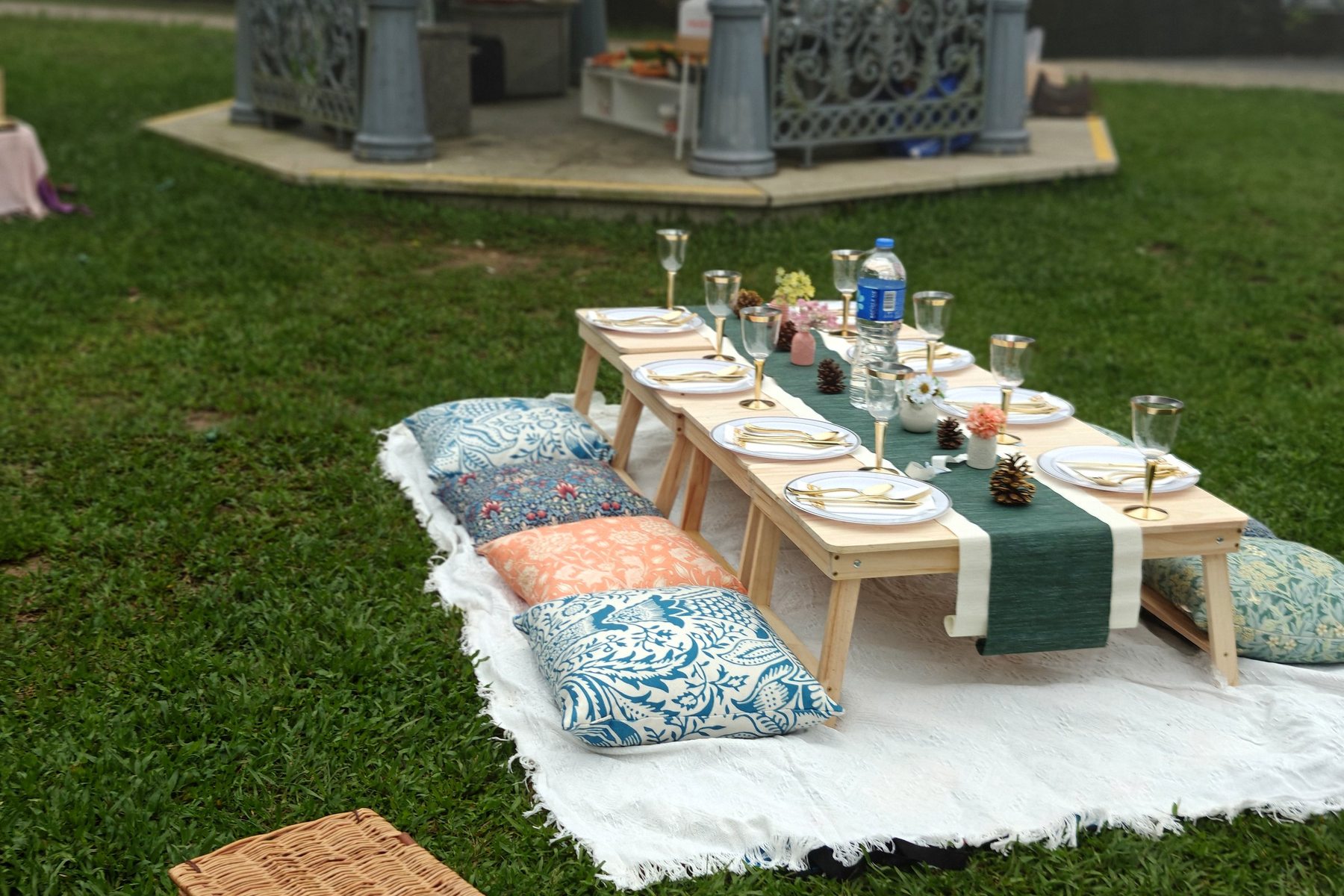 A low picnic table with a green runner and floor cushions